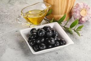 Black olives with oil and branch photo