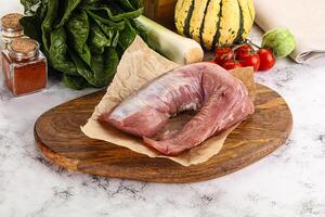 Uncooked raw pork tenderloin with spices photo