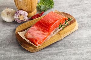 Raw salmon fillet over board photo