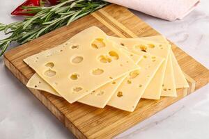 Sliced maasdam cheese with holes photo