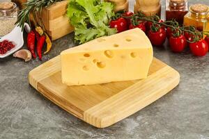 Swiss Maasdam cheese triangle over board photo