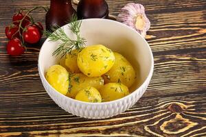 Boiled potato with oil and dill photo