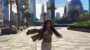 happy girl with long hair spins in the city with a view of high-rise buildings. High quality FullHD footage video