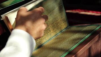 Corano in piedi su il tavolo un' persona chi segue il Linee di il Corano video