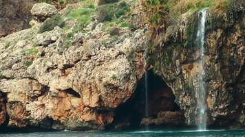 relajante cascada corriendo mediante rocoso acantilados naturaleza 4k vídeo video