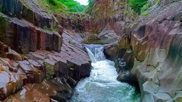 ontspannende waterval rennen door rotsachtig kliffen natuur 4k video