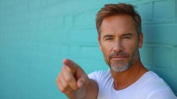 AI generated Casual Man Pointing at Camera Against Blue Wall photo