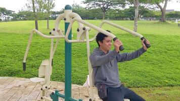 Young man are doing workout activity on the green garden.  The footage is suitable to use for hobbies activity, leisure activity and park background. video