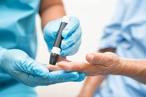 médico cheque diabetes desde dedo sangre azúcar nivel con dedo lanceta. foto