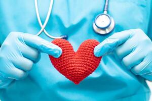 médico sosteniendo un corazón rojo en la sala del hospital, concepto médico fuerte y saludable. foto