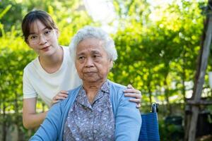 caregiver help and care Asian senior woman patient sitting on wheelchair at nursing hospital ward, healthy strong medical concept. photo