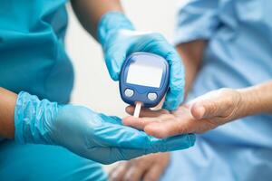 Doctor check diabetes from finger blood sugar level with finger lancet. photo