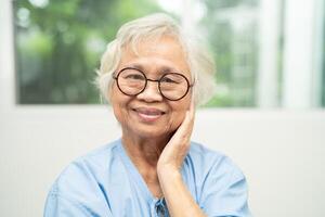 Asian senior woman wearing eyeglasses or vision glasses at home care service. photo