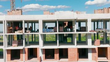 aéreo ver construcción trabajo a el construcción sitio. constructores son edificio paredes en un monolítico edificio. video