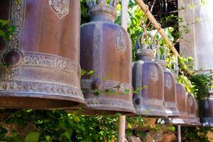 Hanging brass bells arranged on the temple terrace photo