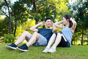 asiático Pareja hacer ejercicio juntos en el parque en el Mañana ellos son fuerte y saludable. al aire libre ejercicio concepto, cuidado de la salud foto