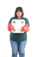 Fat woman wearing red boxing gloves She stood holding a weighing scale. standing on a white background. The concept of being overweight. Exercise to lose weight. white background photo