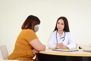 concepto de médico servicios en hospitales asiático hembra médico tratando obeso hembra paciente vistiendo mascarilla. obeso salud cuidado foto