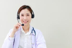 asiático hembra médico sonriente hermosamente Proporcionar tratamiento servicios para pacientes con en línea conversaciones vía el Internet en ordenador portátil ordenadores. en línea médico concepto. Copiar espacio foto