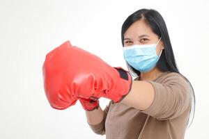 Fat Asian woman wearing a mask and wearing red boxing gloves. Do boxing moves to prevent coronavirus or other diseases. health care concept. white background photo