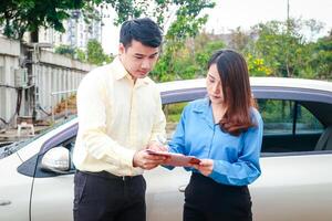 Woman signing paperwork to claim car insurance with insurance company employee Because she was driving a car accident on the road. car insurance concept photo