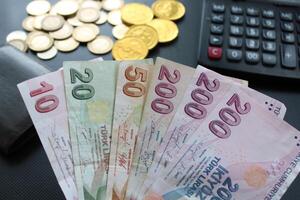 turco lira billetes de banco, monedas y calculadora papel moneda de Turquía en blanco antecedentes. para impuesto, aumento y mínimo salario noticias. foto