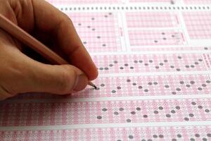 Exam, a hand taking a test with a pencil over an optical reader. Future Anxiety. Uncertainty. photo