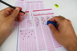 examen, un mano tomando un prueba con un lápiz terminado un óptico lector. futuro ansiedad. incertidumbre. foto