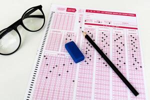 Optical reader, pencil, glasses, and eraser on it. Exam, idea conspet. Future Anxiety. Uncertainty. Multiple choice exam.Adults taking the exam. photo