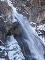 a waterfall in the mountains photo