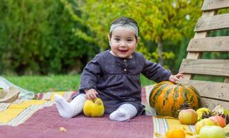 the little child playing in the park with fruits, little girl in the autumn park photo