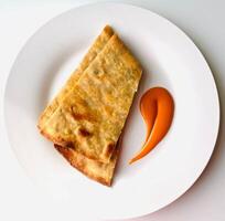 Pancakes with tomato sauce on a white plate on a white background photo