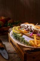 hot dog with french fries and vegetables on a wooden background. selective focus photo