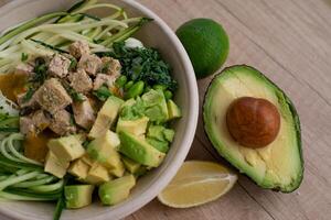 Vietnamese noodle soup with pork and avocado on wooden table photo