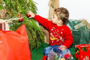 the little child playing with christmas decorations in studio, little child with christmas ball photo