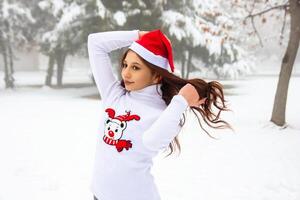 bonito niña en invierno bosque, joven mujer en invierno parque foto