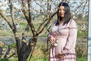 the pregnant woman in the park, beautiful woman in the park, pregnant woman in spring photo