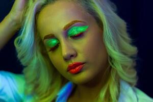 retrato de un mujer con pintado rostro, mujer con uv maquillaje en estudio, retrato de un mujer en carnaval mascarilla, el mujer es decorado en un ultravioleta polvo foto