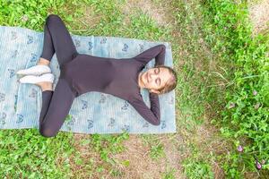 bonito niña haciendo yoga ejercicios, pequeño niña haciendo yoga ejercicios en el jardín foto