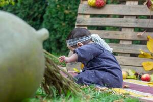 the little child playing in the park with fruits, little girl in the autumn park photo