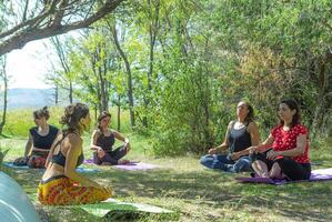 group of people doing yoga exercise in the park, womans relaxing in the park photo