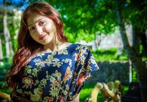 rojo peludo mujer en el parque, bonito mujer en el naturaleza foto