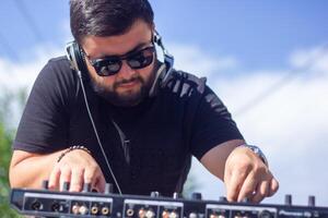 dj with headphones and mixer in the park, the dj at work photo