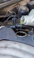 Motor oil pouring to car engine photo