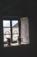 two pots sit on a window sill in a dark room photo