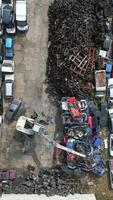 Crane crashing scrap metal cars in a junkyard. video