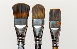 AI generated Three paint brushes arranged in a row against a white backdrop, celebrate artistic day photo