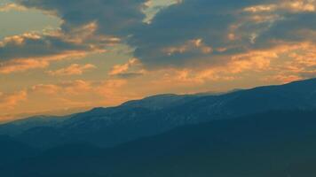 zonsopkomst over- bergen. gekleurde wolken drijvend. zonsondergang of zonsopkomst lucht. pan. video