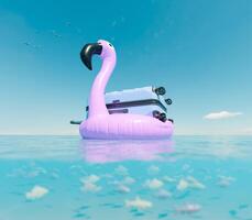 flotante rosado flamenco inflable con maleta en Oceano foto
