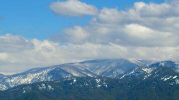 Forest In The Snowy Mountains. Snow-Capped Mountains And Forest Bathed In Bright Sun. Timelapse. video